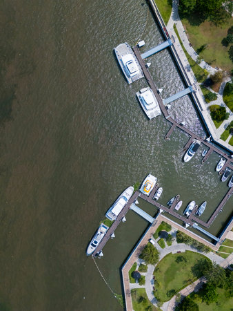 Boat is docked at a marina. There are several boats in the water. The marina is located near a park