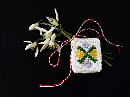 Traditional sewing pattern with red and white string, known as Martisor. It is a Romanian traditional symbol of the beginning of spring. Isolated on black background.の写真素材