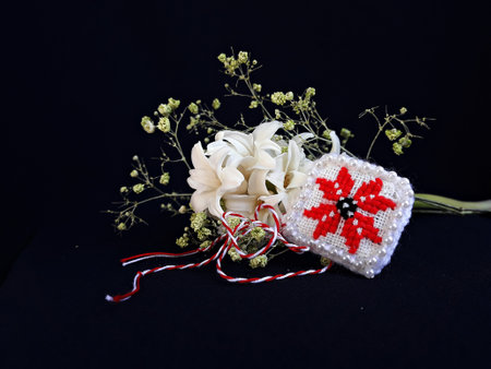 Traditional sewing pattern with red and white string, known as Martisor. It is a Romanian traditional symbol of the beginning of spring. Isolated on black background.の写真素材