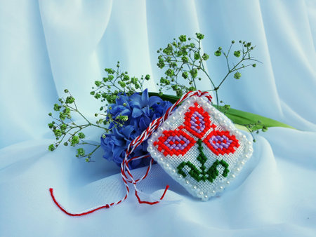 Traditional sewing pattern with red and white string, known as Martisor. It is a Romanian traditional symbol of the beginning of spring. Isolated on white background.の写真素材