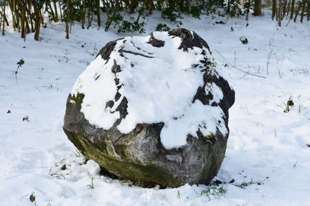 Decorative stone covered with snow in the park.の写真素材