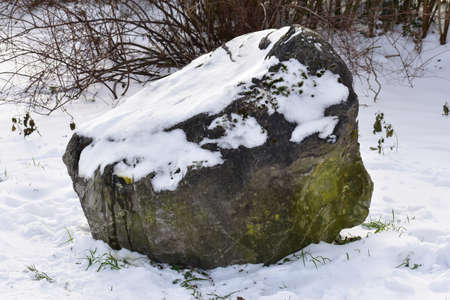 Decorative stone covered with snow in the park.の写真素材