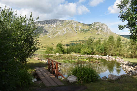 View of the beautiful garden with lake, of the guest house Conacul Secuiesc from Coltesti village, Romania and Piatra Secuiului in the background.の写真素材