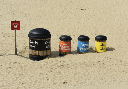 Set of recycling trash containers with glass, paper, plastic and other waste, on Scheveningen beach in The Hague, Netherlands.の写真素材