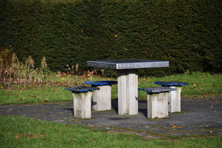 Concrete table with four chairs in the park.