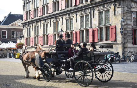 September- 10- 2019. Tourists in a carriage, drawn by 2 horses, on the market square in Delft, Netherlands.のeditorial素材