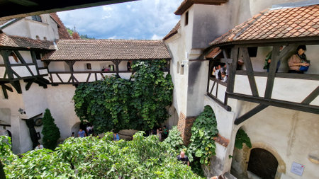 August 11, 2023. Inner courtyard of the Bran castle, home of the legendary vampire, Count Dracula, Romania. Tourists visiting the castle.のeditorial素材