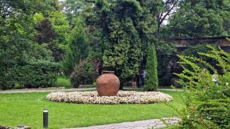 August 11, 2023. View of a beautiful garden in front of Bran Castle, also known as Dracula's Castle, in Transylvania, Romania. Ceramic vase on the lawn in the garden.のeditorial素材
