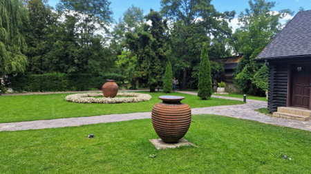 August 11, 2023. View of a beautiful garden in front of Bran Castle, also known as Dracula's Castle, in Transylvania, Romania. Ceramic vase on the lawn in the garden.のeditorial素材