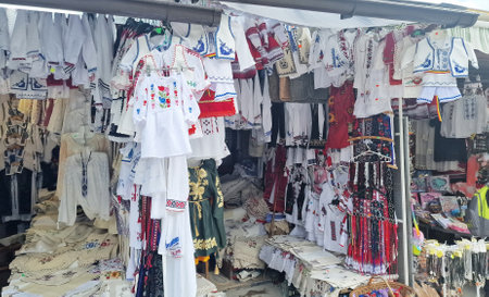 August 11, 2023. Shop with traditional souvenirs for sale, on the market, near Bran Castle, Romania. Traditional Romanian blouses sewn by hand.のeditorial素材