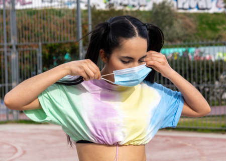 small hands with surgical mask on basketball court in summer