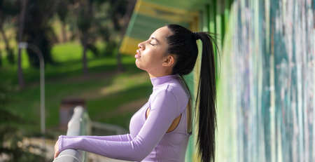 young girl with closed eyes on the bridge and with long black hairの写真素材