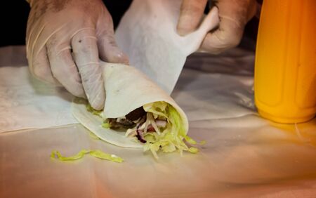 hands preparing tacos and felafel at street fairの写真素材