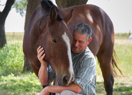 Smiling man with his horse in the Argentine countrysideの写真素材