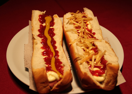 big hot dog with sauces and french friesの写真素材