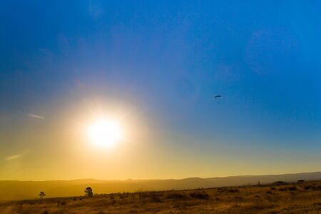 landscape of the eclipse in the mountains and paragliding in the skyの写真素材
