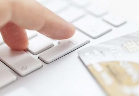Man is entering credit card information to computerの写真素材