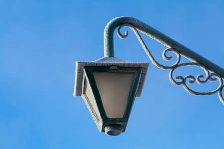 Close-up photograph of street light and pole with a blue sky の写真素材