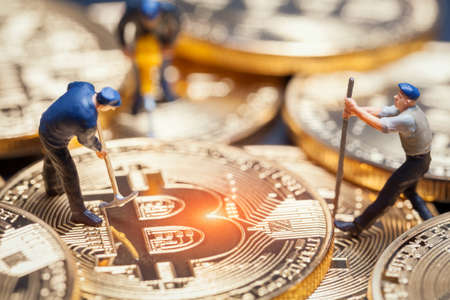 macro miner figures working on group of bitcoins. virtual cryptocurrency mining concept