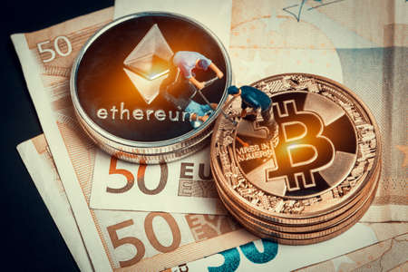 macro miner figures working on stack of bitcoin and ethereum placed on euro banknotes. virtual...
