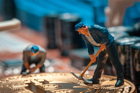 macro miner figurines working on a bitcoin on computer motherboardの写真素材