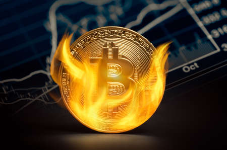 Golden bitcoin burning in flames on stock market chart background. Bitcoin value loss in market concept.の写真素材
