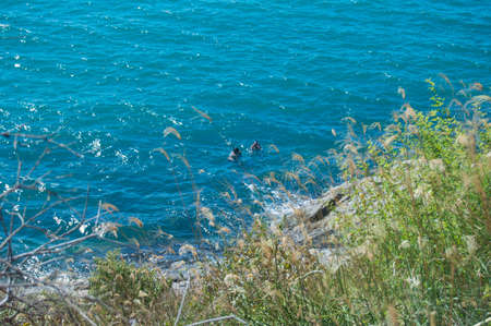 Two divers on a beautiful blue sea at Arraial do Cabo, Brazilの写真素材