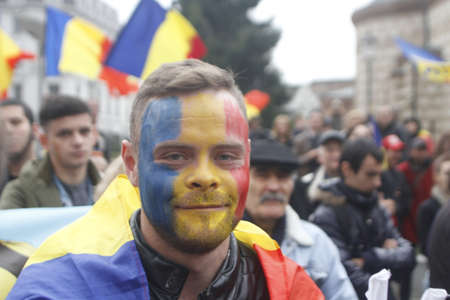 BUCHAREST, ROMANIA - OCTOBER 19, 2016:  A young man with his face painted in the Romanian and Moldovan flag colors attends a rally demanding the union between Romania and the Republic of Moldova.のeditorial素材