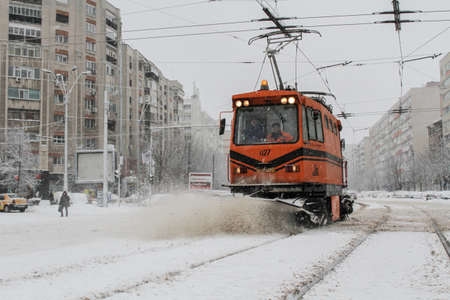 Bucharest, Romania, 17 January 2016: A road sweeping tram clears snow from the road, during a snowfall in Bucharest.のeditorial素材