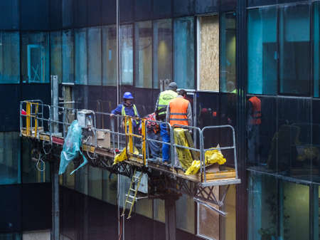 Bucharest, Romania, 1 February 2016: Laborers are mounting windows on a building in a construction site in Bucharest.のeditorial素材