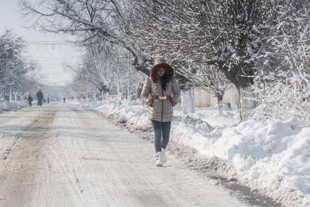 Bucharest, Romania, January 23, 2016: A woman walks on the street after a snowfall in Bucharest.のeditorial素材