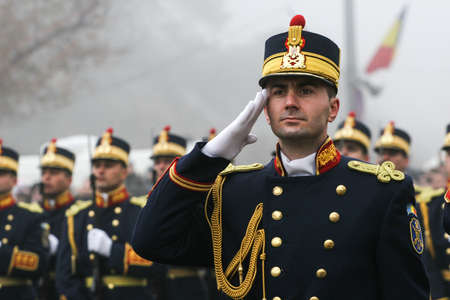 BUCHAREST, ROMANIA - DECEMBER 1, 2008: A military from the National Guard salutes during a military parade. More than 3,000 soldiers and personnel from security agencies take part in the massive parades on National Day of Romania.のeditorial素材