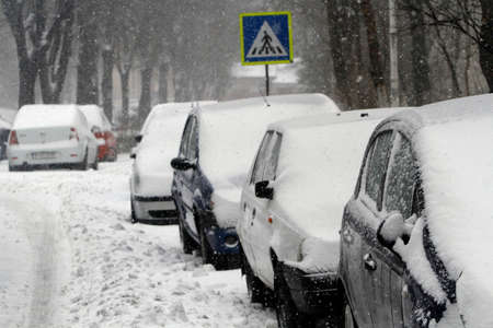 BUCHAREST, ROMANIA - January 06, 2017: Cars covered with snow are seen in parked near the road.のeditorial素材