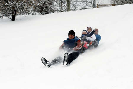 BUCHAREST, ROMANIA - January 07, 2017: Joyful children are sledding down the hills on a winter day, in a central park during the vacation.のeditorial素材