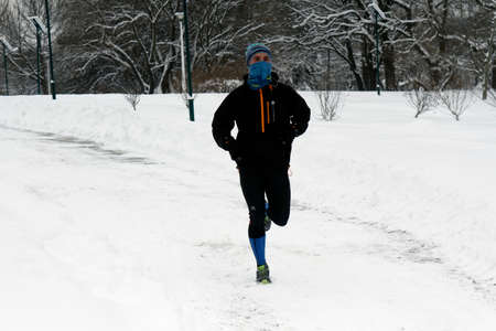 BUCHAREST, ROMANIA - January 07, 2017: A sportsman runs on snow in the central park, in a winter day during the vacation.のeditorial素材
