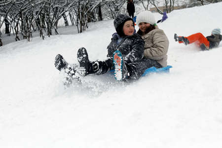 BUCHAREST, ROMANIA - January 07, 2017: Joyful children are sledding down the hills on a winter day, in a central park during the vacation.のeditorial素材