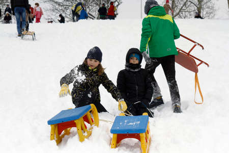 BUCHAREST, ROMANIA - January 07, 2017: Joyful children are sledding down the hills on a winter day, in a central park during the vacation.のeditorial素材