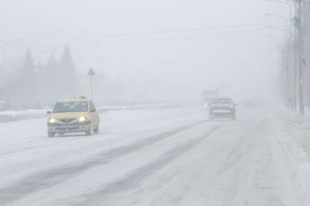 Bucharest, Romania, January 25, 2016: Cars are passing on a snowy road during a blizzard in Bucharest.のeditorial素材