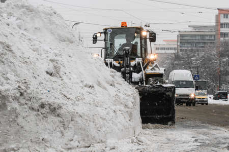 Bucharest, Romania, January 27, 2014: A road sweeping vehicle clears snow from the road, after a snowfall in Bucharest.のeditorial素材