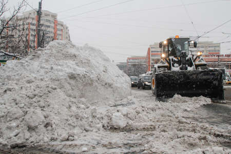 Bucharest, Romania, January 27, 2014: A road sweeping vehicle clears snow from the road, after a snowfall in Bucharest.のeditorial素材