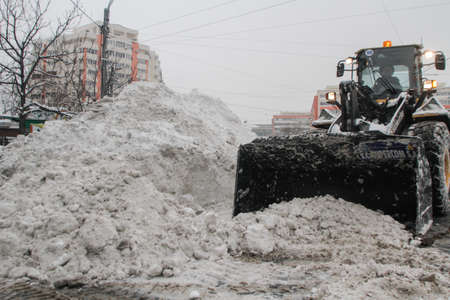 Bucharest, Romania, January 27, 2014: A road sweeping vehicle clears snow from the road, after a snowfall in Bucharest.のeditorial素材