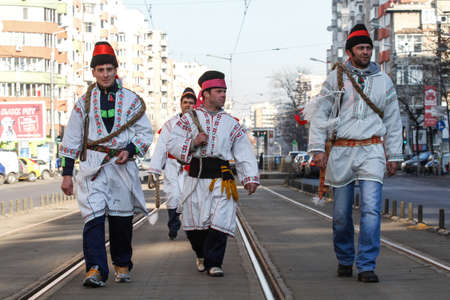 Bucharest, Romania, December 30, 2012: Carolers dressed in national costumes and wearing whips are performing in a tram station in Bucharest.のeditorial素材