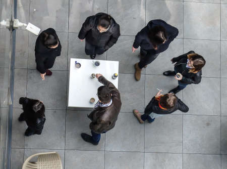 Bucharest, Romania, March 18, 2016: People are smoking and drinking coffee in an outdoor smoking area of an office building in Bucharest.のeditorial素材