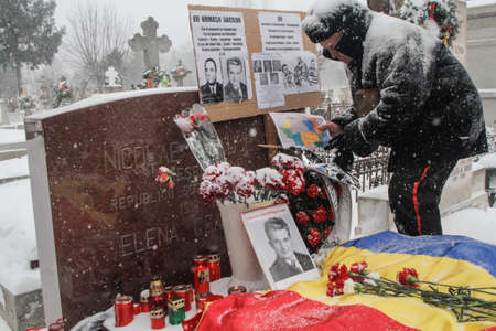 Bucharest, Romania, January 26, 2014: A man puts a map of Romania at the grave of Romania's late communist dictator Nicolae Ceausescu, during commemoration of his birthday. Year after year Romania's nostalgic Communists gather to mourn Ceausescu, who was のeditorial素材