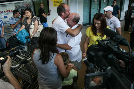 Bucharest, Romania, August 14, 2009: Members of the Italian towboat Buccaneer who were kidnapped by Somali pirates in Aden Gulf on August 9-10, are welcomed by their families and press representatives on the Henri Coanda airport.のeditorial素材