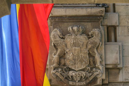 Bucharest, Romania, August 23, 2009: The royal emblem of Romania on the Triumph Arch in Bucharest and the Romanian flag.のeditorial素材