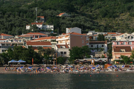 Becici, Budva, Montenegro, May 23, 2009: People on the beach and houses in the background  in the old center of Becici.のeditorial素材