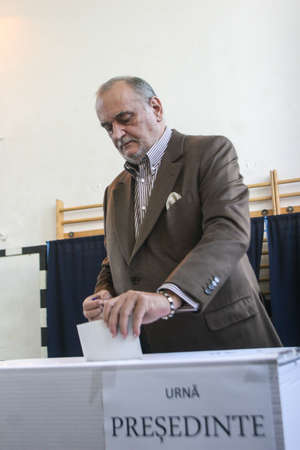 Bucharest, Romania, November 22, 2009: Politician and business man Dinu Patriciu votes for the presidential elections, in a polling station in Bucharest.のeditorial素材
