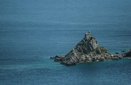 Becici, Budva, Montenegro, May 21, 2009: A small chapel on a rocky cliff in the Adriatic sea.のeditorial素材
