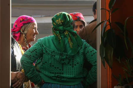 Sintesti, Ilfov county, Romania, November 22, 2009: Gypsy women wait outside of a polling station in Sintesti, to vote for the presidential elections.のeditorial素材